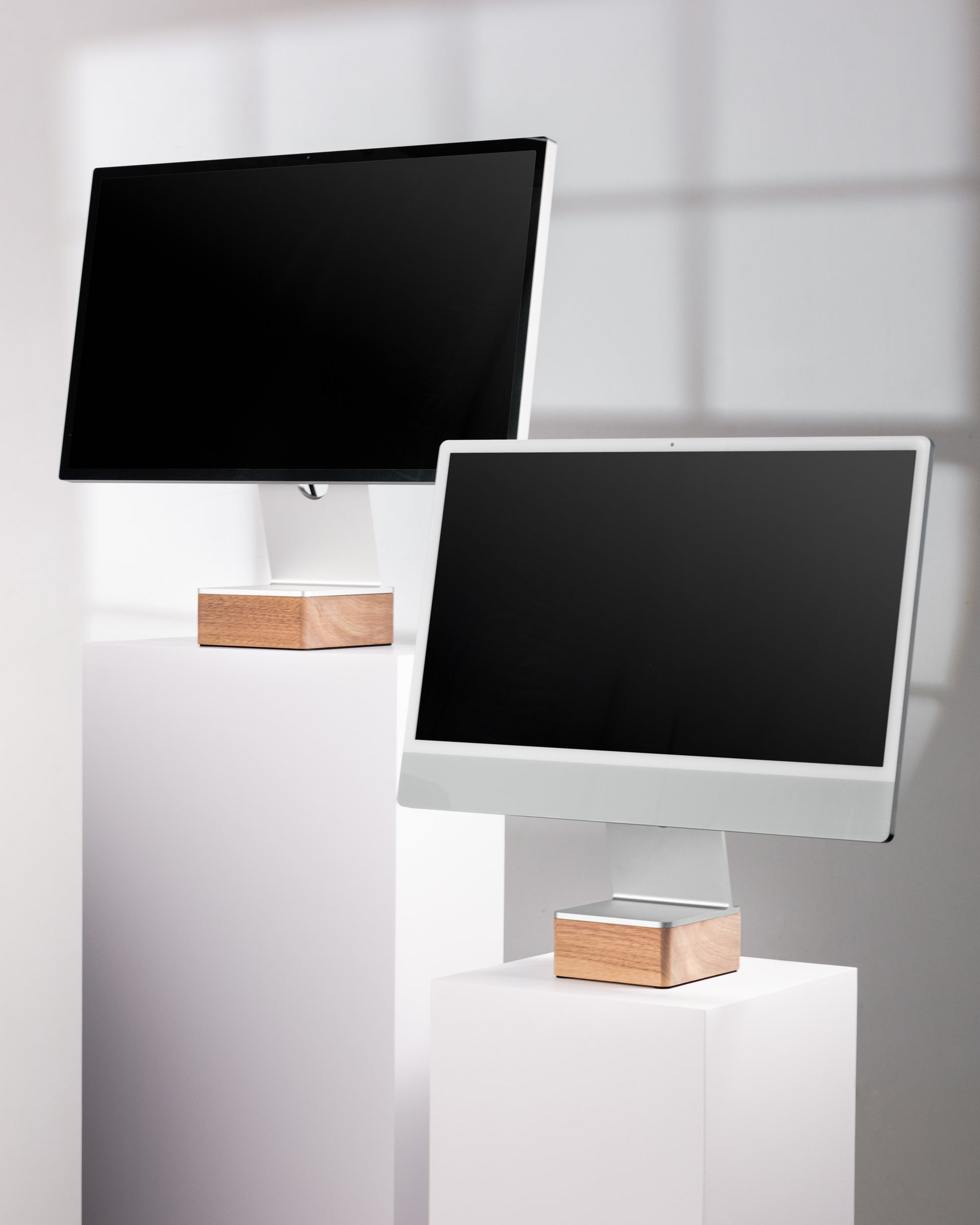 Two computer monitors on Solid Studio Display Riser and Solid iMac 24" Riser against a white wall