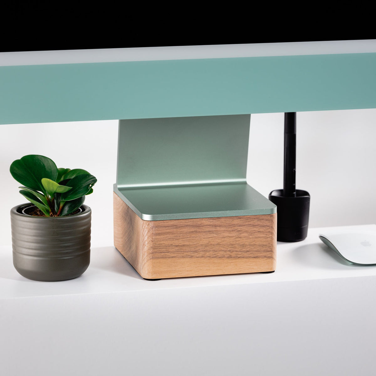 Desk setup with a computer monitor, plant, and solid 24” iMac Riser in walnut