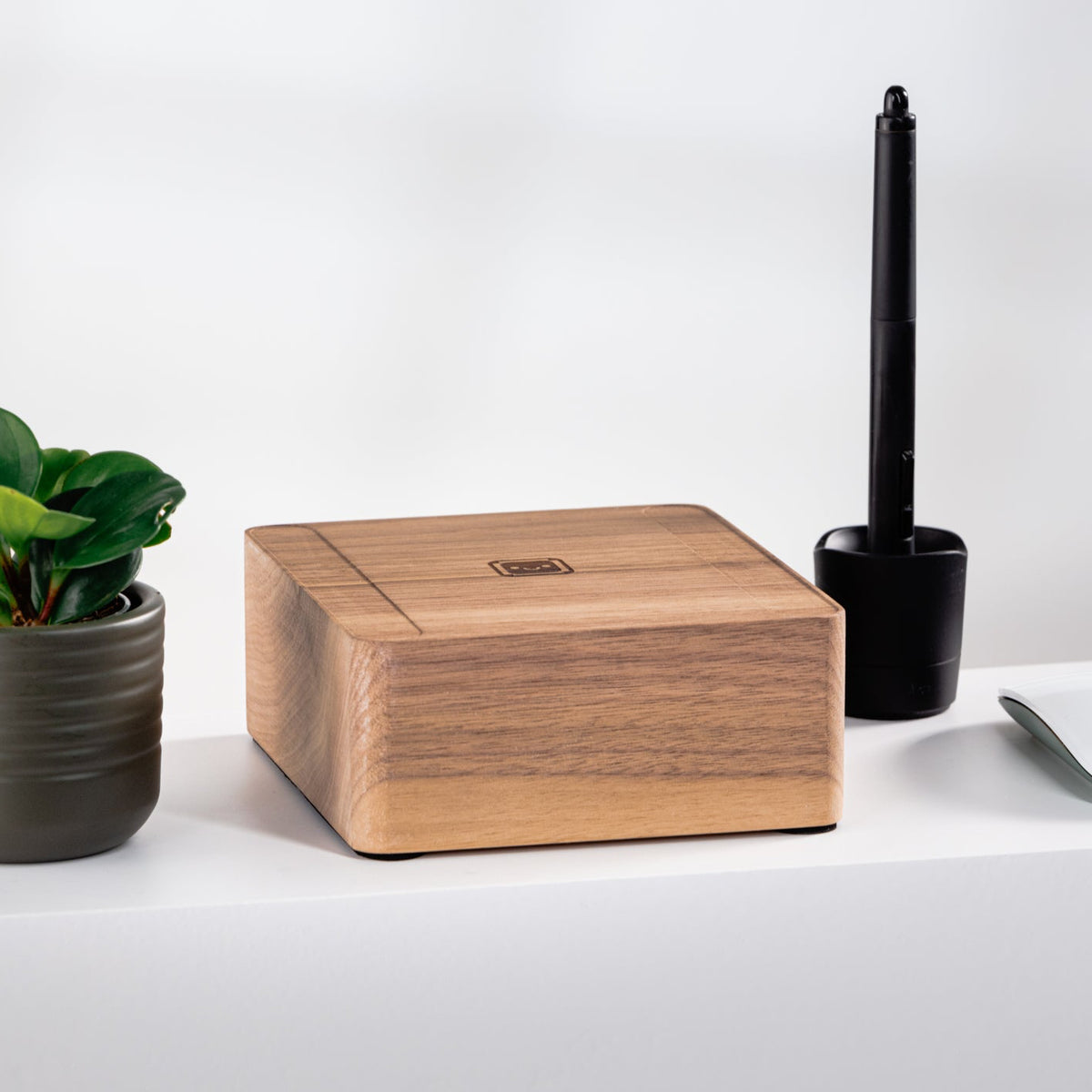 Wooden 24” iMac Riser, potted plant, and other items on a white surface with a white background