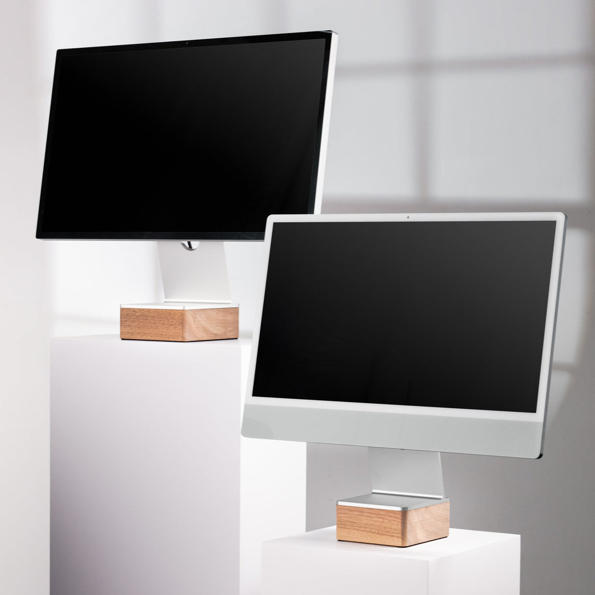 Two computer monitors on Solid Studio Display Riser and Solid iMac 24" Riser against a white wall